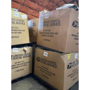 USPS high piece count truckload of shrink-wrapped undeliverable parcel pallets on a loading dock