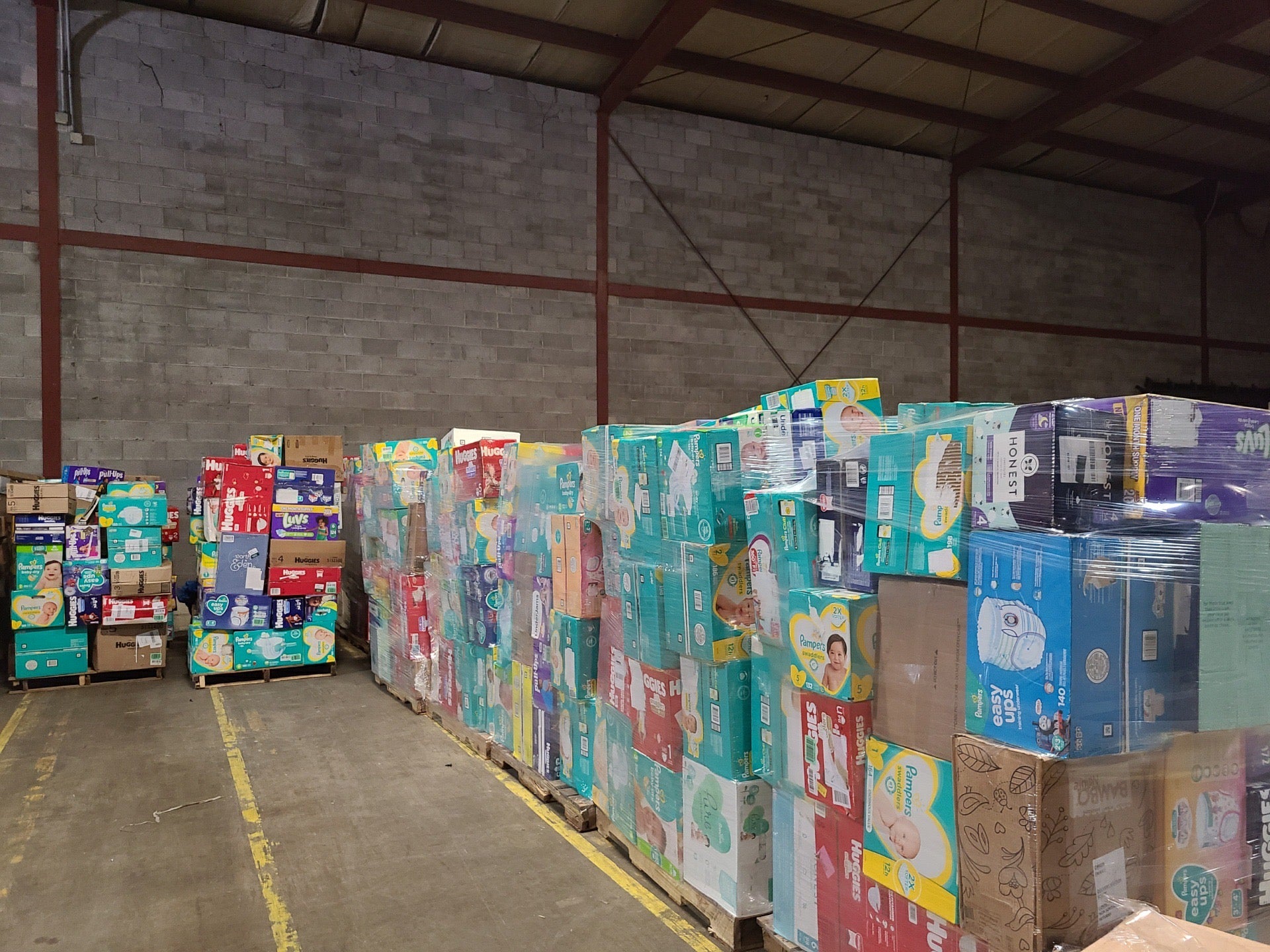 Pullups-Truckload Bulk diaper truckload of shrink-wrapped overstock Pampers and Huggies diaper pallets ready for resale