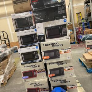 Microwave liquidation pallet stacked with assorted countertop and over-the-range microwaves for resale