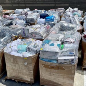 Bedding items wholesale pallet stacked with comforters, sheet sets and mattress protectors for resale